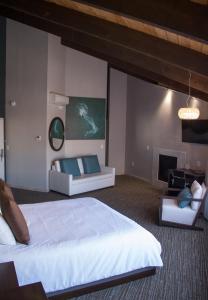 蒙特雷蒙特利浪子旅馆的一间卧室设有一张大床和一个壁炉