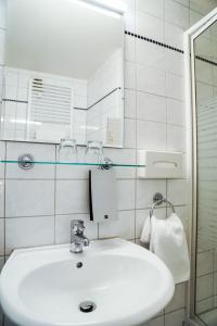 美因河畔法兰克福尼德雷德霍夫酒店的白色的浴室设有水槽和镜子