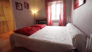 马扎梅La Prade des "Pierre"的一间卧室配有一张带红色枕头的床