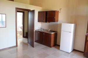 MiglionicoAgriturismo L'Assiolo的厨房配有白色冰箱和木制橱柜。