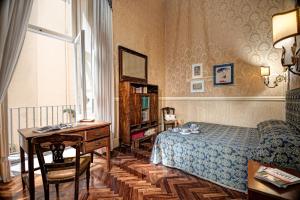 那不勒斯Arthouse Lady Marys Tribunali Luxury Suite的一间卧室配有一张床、一张书桌和一张书桌。