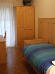 卡纳泽伊La Campagnola的一间卧室配有一张床和一个木制橱柜
