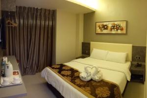 马六甲金叶酒店的酒店客房,配有一张带两个天鹅的床