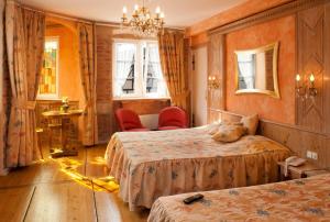 科尔马Hotel Saint-Martin的酒店客房设有两张床和吊灯。