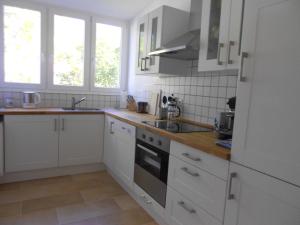 弗莱堡Quartier 1的厨房配有白色橱柜和炉灶烤箱。
