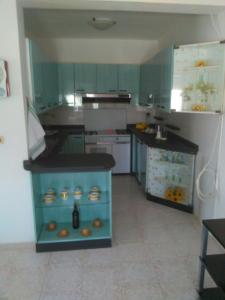 托雷莫泽Appartamento Alba vista spiaggia的厨房配有绿色橱柜和蓝色台面