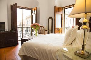 瓦哈卡市卡萨西耶特巴尔肯斯精品酒店的一间卧室配有一张床和一张带台灯的桌子