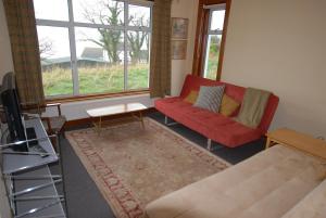 纽敦纳兹The Hide的客厅配有红色的沙发和桌子
