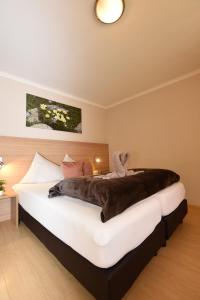 瑟弗浩斯基尼化玛旅馆的一间卧室配有一张大床,床上有毯子