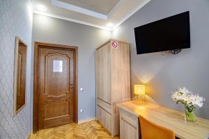 利沃夫Premium Hostel的一间设有一张桌子和一台墙上的电视的房间