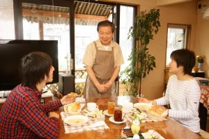 札幌札幌纳达酒店的站在餐桌前吃食物的人