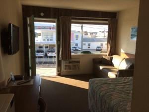 怀尔德伍德Crystal Sands Motel的酒店客房设有床、沙发和窗户。