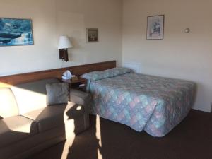 怀尔德伍德Crystal Sands Motel的酒店客房,配有床和沙发