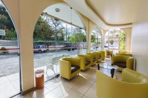 弗洛里亚诺波利斯Tri Hotel Florianópolis的一间设有黄色椅子和桌子的等候室,窗户