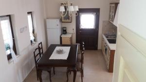 卡米拉日埃莱尼别墅酒店的厨房配有桌椅和冰箱。