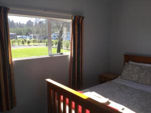 WetheralKairaki Beach Motor Camp的一间卧室设有一张床和一个窗口