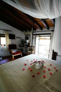 卡科佩特里亚艾琳之家酒店的一间卧室,床上铺有红色玫瑰花瓣