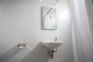 当格浪航空城德格林酒店的白色的浴室设有水槽和镜子