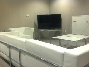 玛德琳港考斯塔内拉酒店的客厅配有白色家具和平面电视