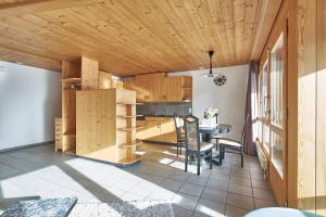 哈斯利伯格卢伟莉公寓的厨房配有木制橱柜和桌椅