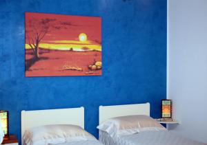 科尔萨诺B&b Tratturi的蓝色墙壁客房的两张床