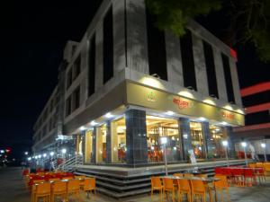 舍地寺庙景观酒店的大楼前的餐厅,配有橙色的桌椅