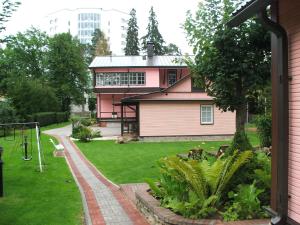 纳尔瓦约埃苏瓦伦蒂娜帕思奈特酒店的一座粉红色的房子,在院子里设有游乐场