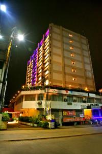 门格洛尔彭亚国际酒店的一座大建筑,晚上有紫色的灯光