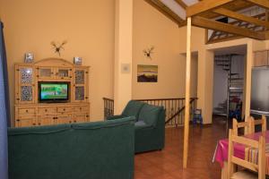 加拉奇科Casa en Garachico的客厅配有两把椅子和电视