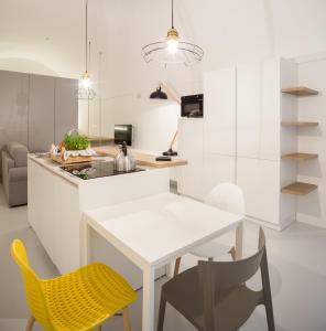 莫诺波利B22 - COMFY BEAUTIFUL LOFT的厨房配有白色的桌子和黄色的椅子