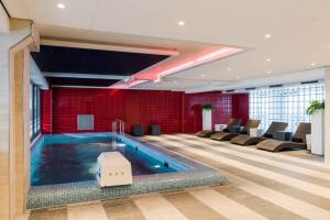 阿姆斯特尔芬阿姆斯多芬服务式公寓酒店的一个带椅子的房间和一个大型游泳池,