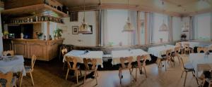 瓦门施泰纳赫Hotel Bergblick的一间设有白色桌椅的用餐室