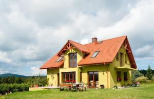茨兹伊特纳Apartamenty w Gorach Stolowych的黄色房子,有橙色屋顶