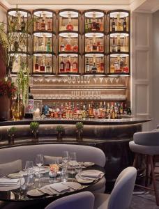 伦敦梅宝尼康诺酒店的一间带桌椅的餐厅和酒吧