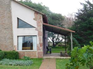乌拉圭河畔康塞普西翁Cabañas Tierra Linda的房屋设有窗户和庭院
