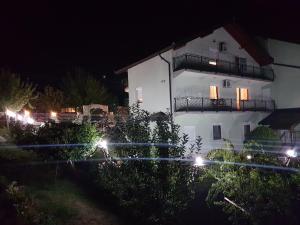 萨拉热窝Guest house Dinka的白色的建筑,在晚上有灯