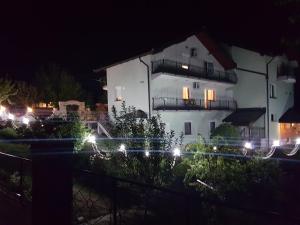 萨拉热窝Guest house Dinka的白色的房子,晚上有灯在前面