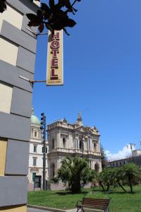 庞贝Hotel Il Santuario - Pompei的前面有标志的建筑,有长凳