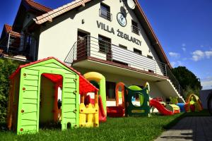 鲁斯诺沃APARTAMENTY-Villa Żeglarzy的一座有孩子的建筑前面有游戏设备