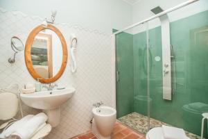 Montecalvo in FogliaCa' Virginia Country House Wellness的浴室配有盥洗盆和带镜子的淋浴