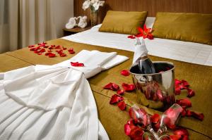 纳塔尔维拉公园酒店 的床上有一瓶葡萄酒和红花