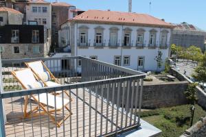 波尔图Amazing Penthouse Apartment in historic Porto的阳台配有两把椅子,大楼