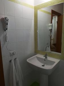 蒙特齐尔佛奈Residenza Skanderbeg的浴室配有盥洗盆、镜子和毛巾