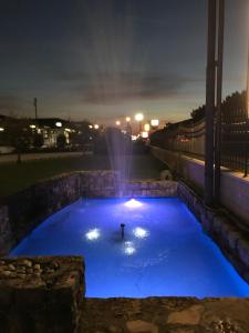 雷扎托拉皮纳酒店的一个人在晚上在一个带喷泉的游泳池里