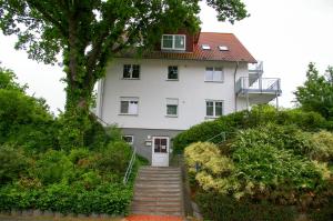 奥斯特西巴德钦诺维茨Fewo Zinnowitz Ostseequartett的白色的房子,有楼梯通往