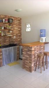 穆库热O Pouso Condomínio的厨房配有柜台和一些凳子
