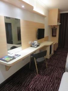 加影RHR Hotel Kajang的酒店客房配有书桌和镜子