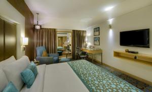 艾哈迈达巴德艾哈迈达巴德普莱德广场酒店的酒店客房设有床和客厅。