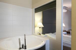 布达佩斯八角形房舍酒店的带浴缸和镜子的浴室