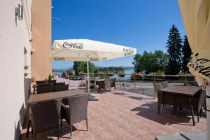 纳梅斯托沃Hotel Slanica的一个带桌椅和遮阳伞的庭院